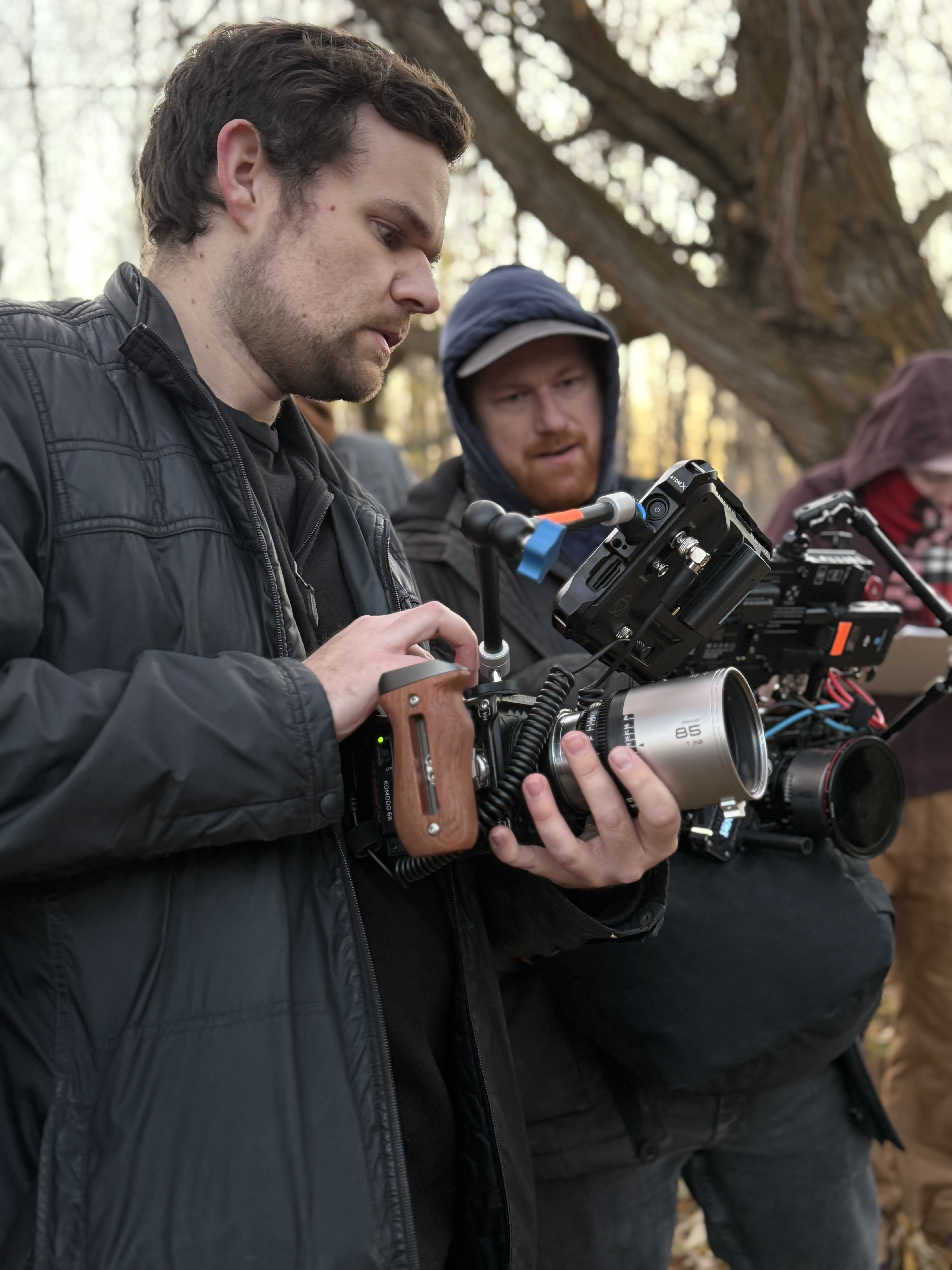 Crew members checking a cinema camera in a forest location