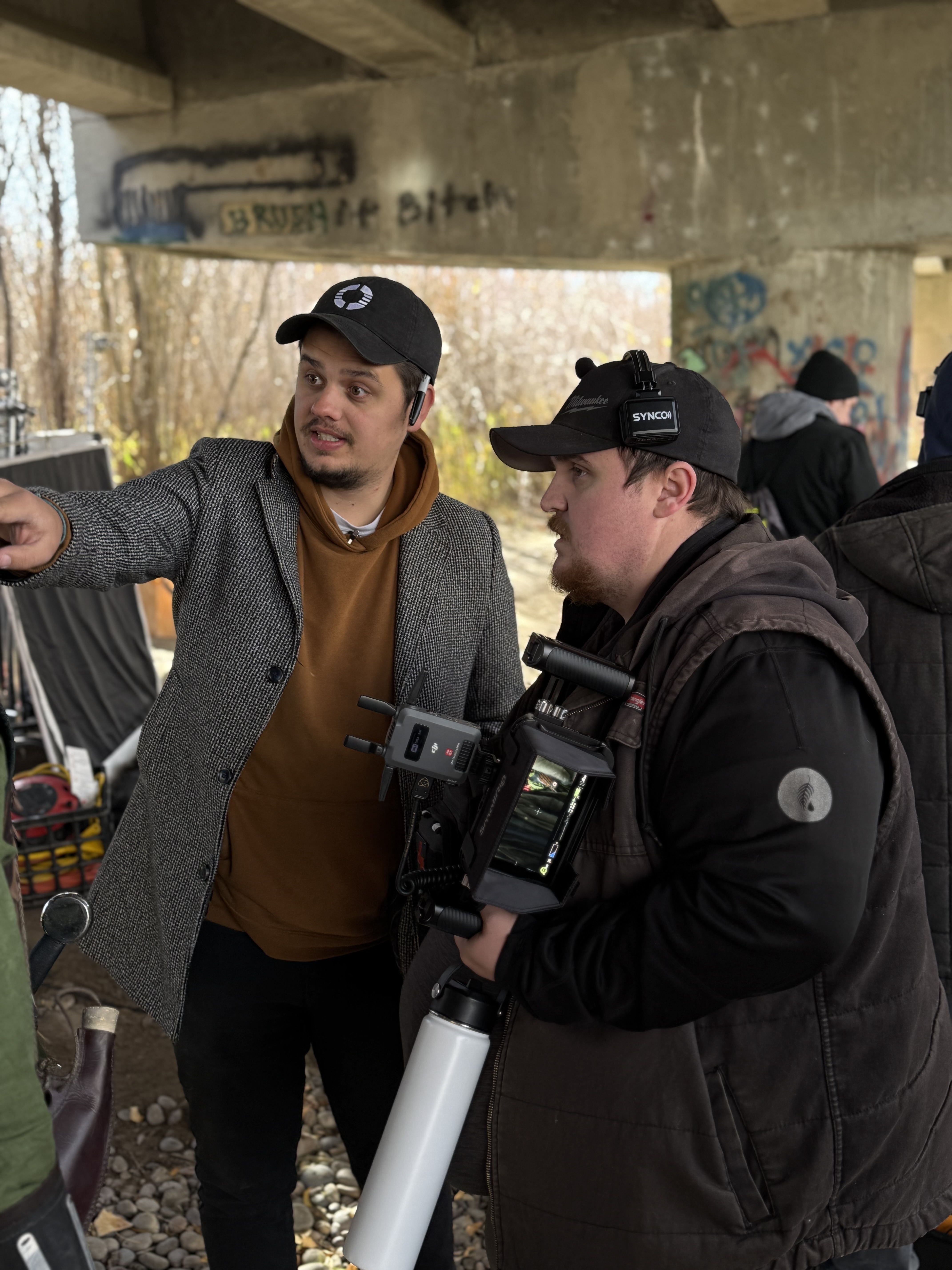 Director and camera operator planning a shot under a bridge