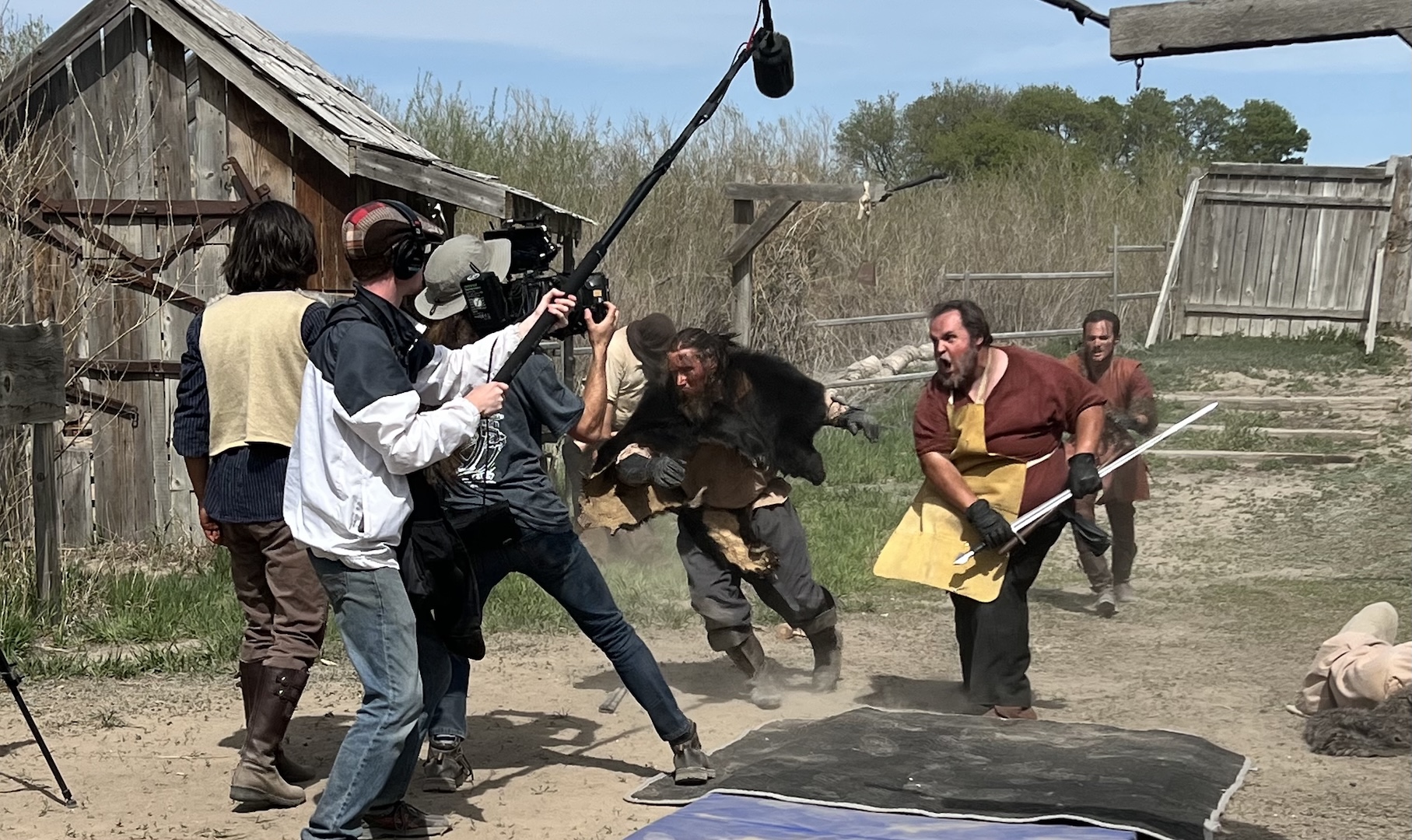 Crew filming an outdoor action scene with boom audio and camera