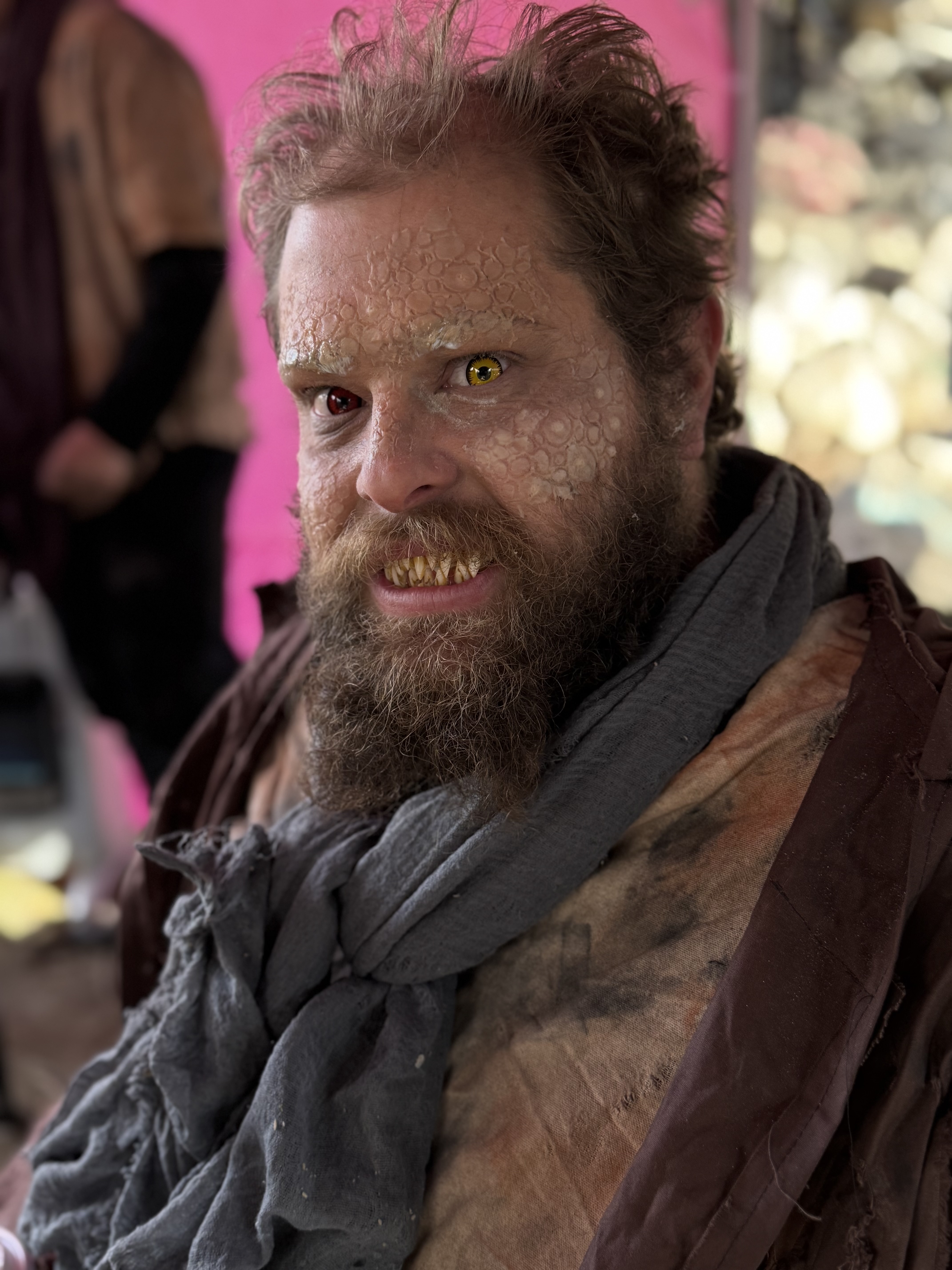 Actor in creature makeup with prosthetics and colored contact lenses